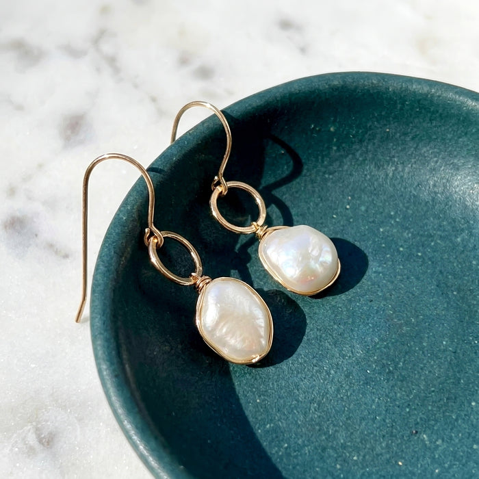 Chubby baroque pearl hammered gold filled drop earrings on teal ceramic dish