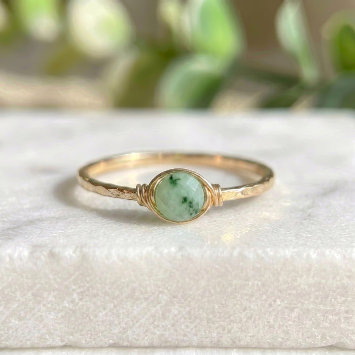 Dainty jade stacking ring gold filled on white marble background light and dark green rose cut jade wire wrapped setting