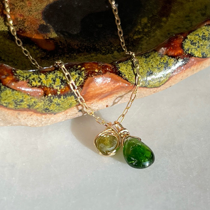 Gold filled wire wrapped dainty two tone asymmetrical green natural gemstone briolette necklace with chrome diopside and green tourmaline on ceramic jewelry dish