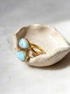 Gold larimar adjustable teardrop two stone ring on ceramic dish side view