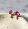Sterling silver pink tourmaline celestial stud earrings with tiny clear topaz accent stones leaning on off white ceramic jewelry dish