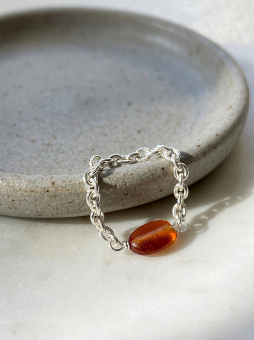 Garnet rolo chain statement ring sterling silver on ceramic dish