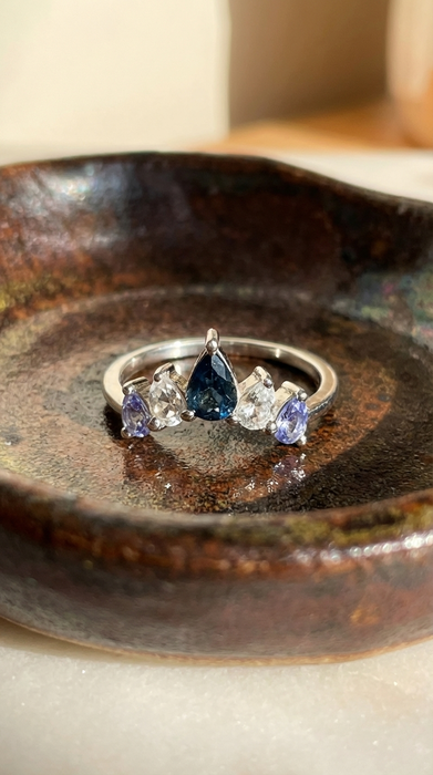 Sterling silver sapphire clear topaz and tanzanite natural gemstone chevron cluster ring or crown ring in brown ceramic jewelry dish full front view